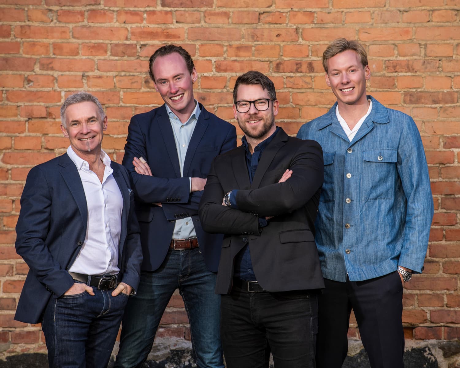 Micke, Alfred, Arvid & David står tillsammans framför en tegelvägg