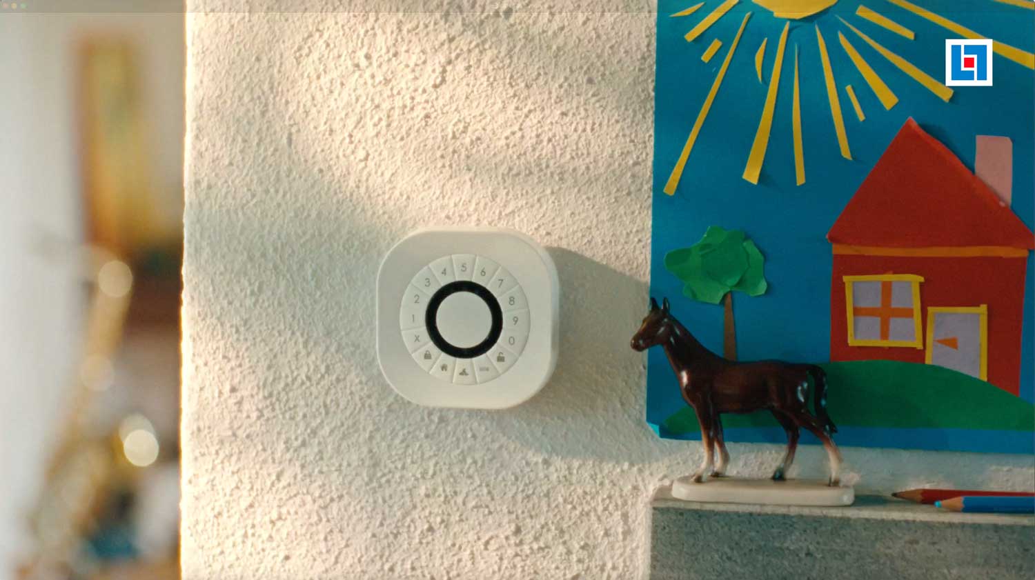 En närbild på ett hus. På väggen sitter Länsförsäkringars nya hemlarm