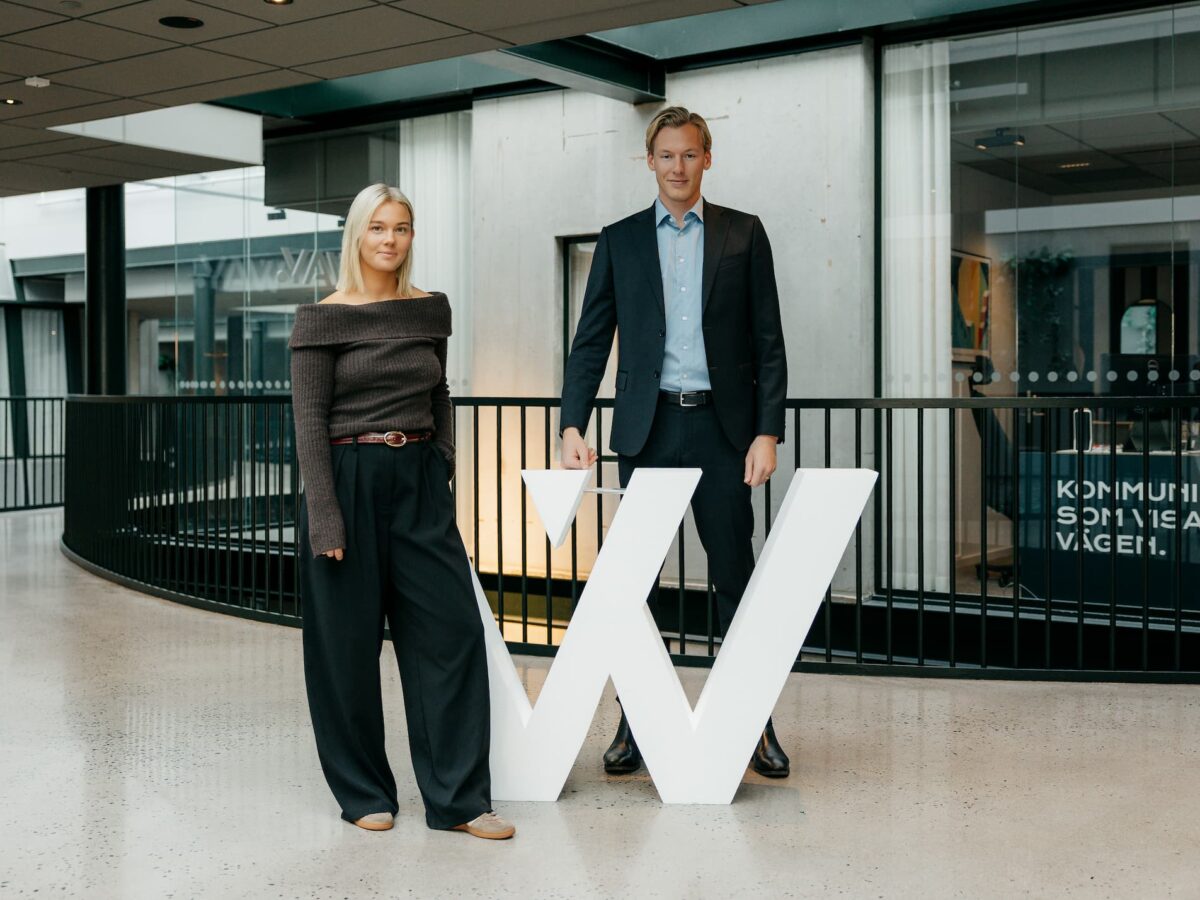 Bild på Lisa och David framför ett stor W i frigolit.