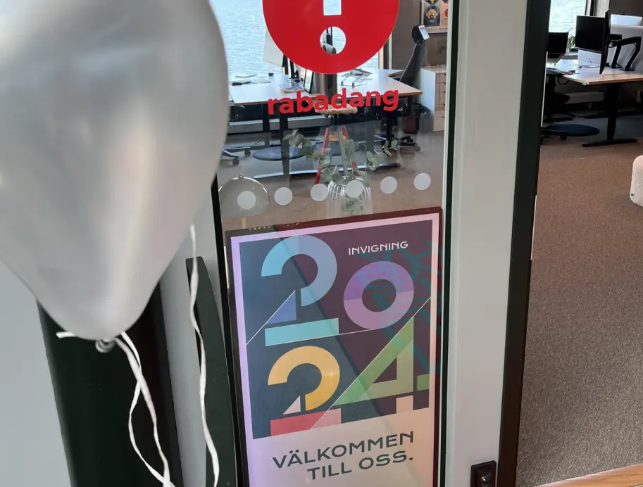 En bild på ingången med en skylt för invigningen 2024 för det nya kontoret.