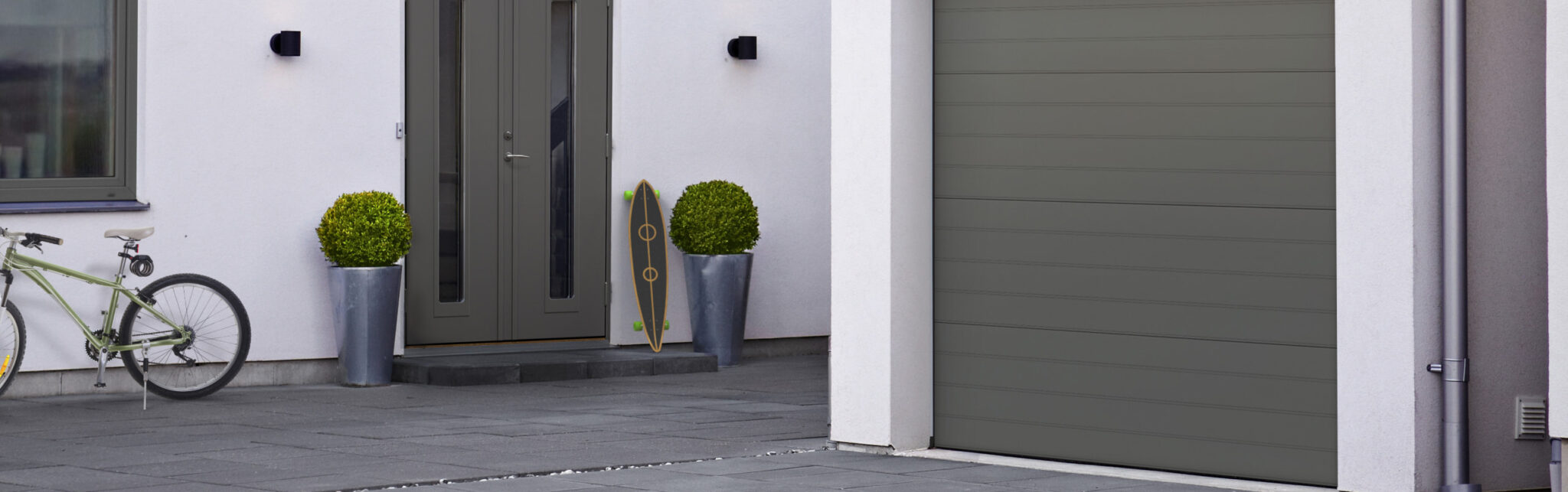 3D visualisering av en trädörr samt garagedörr på ett putsat vitt hus.